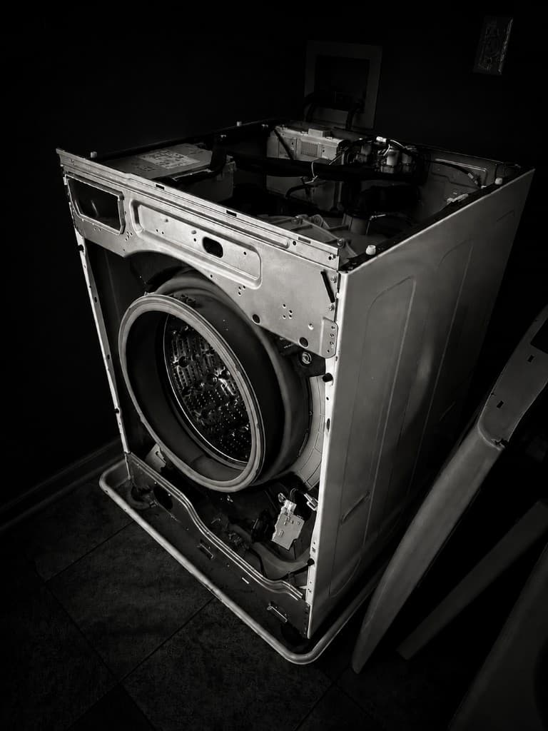 Front-load washer opened for service, drum and internals exposed